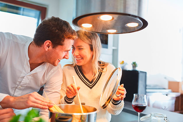 Ein Paar steht in der Küche und kocht Pasta